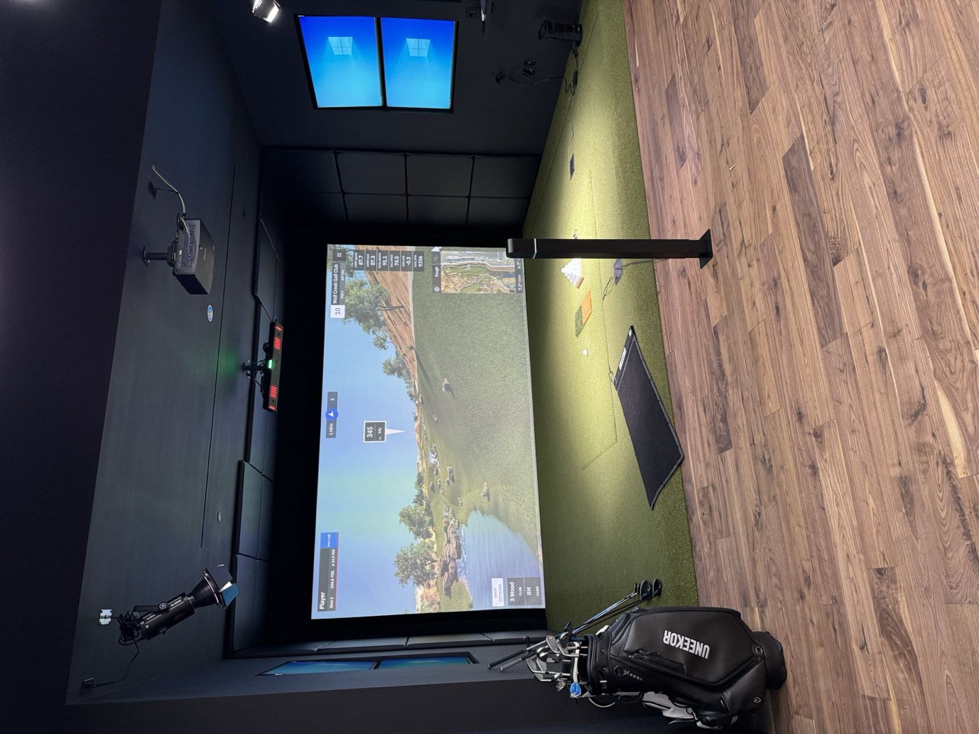 Golf simulator showroom bay with projection screen and turf, Uneekor retail experience center buildout